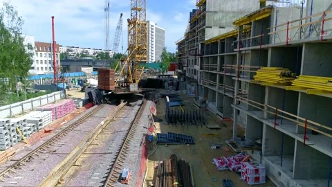 Flying over construction site towards tower crane with construction materials Stock Footage 156025353