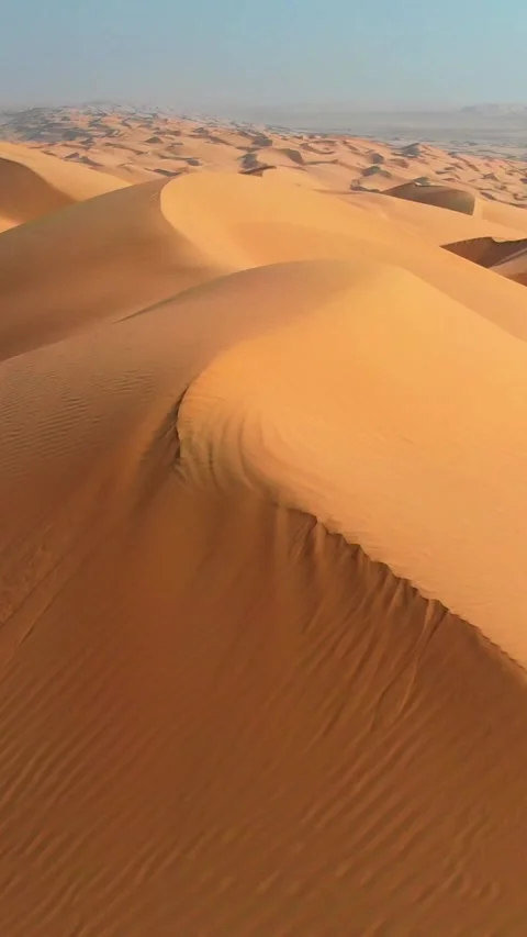 Flying over curve shaped sand dunes during hot summer weather. Rub' al Khali Stock Footage 274736613