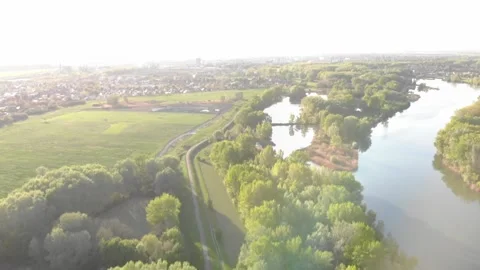 Flying over a cycle road on the riverside in the sunset Stock Footage 232486856