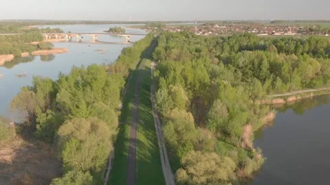 Flying over a cycle road on the riverside in the sunset Stock Footage 232487058