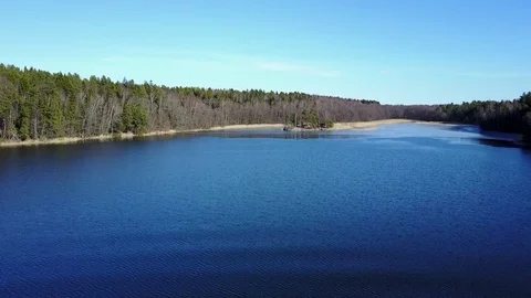 Flying over a deep blue Lake in the Forest - Aerial Flight Stock Footage 73901029