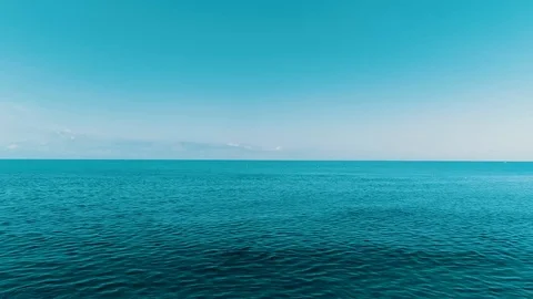 Flying over the deep, undulating sea at dawn. The vast blue water and the Stockbeeldmateriaal 111158565