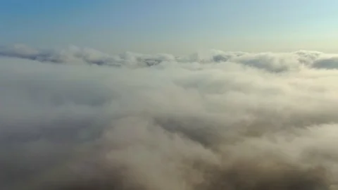 Flying over a dense layer of white clouds that are illuminated by the bright sun Stock Footage 128634323