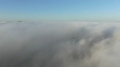 Flying over a dense white mist from which stick out only the tops of the mountai Stock-Footage 132170711