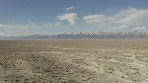 Flying over the desert of Nevada with snowcapped mountains in the distance Stock Footage 169974985