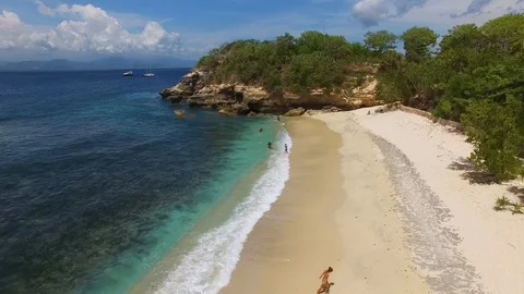 Flying over deserted beach to a small cliff Stock Footage 111777103
