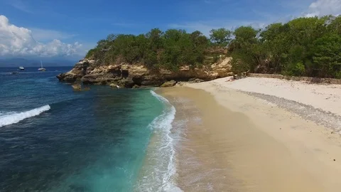 Flying over deserted beach to a small cliff Stock Footage 111778645