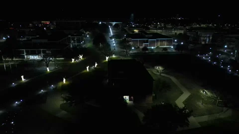 Flying over a down town city park area at night in 4K Stock Footage 296784665