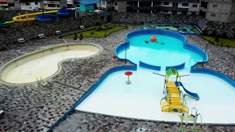 Flying over an empty swimming pool with a slide in front of it Stock Footage 234969444