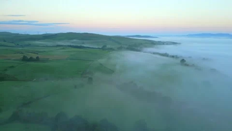 Flying over English patchwork fields with misty fog bank at sunrise. Stock-Footage 248494958