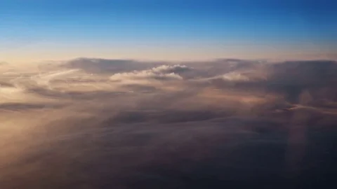 Flying over the evening clouds with the late sun. A view through an window. Vidéo 78615378