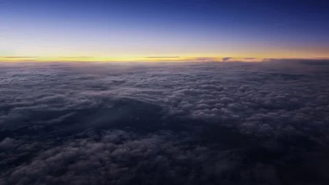 Flying over the evening clouds with the late sun. A view through an window. Stock Footage 78710726