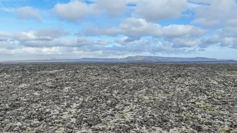 Flying over an expansive field of lava rock covered in moss in Grindavik Iceland Stock Footage 314281535
