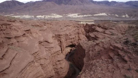 Flying over a fault in the ground, a canyon in red rocks Stock Footage 236122859