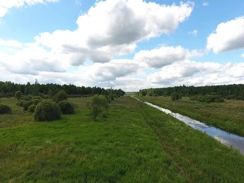 Flying over the field and the river at low altitude  Stock Footage 70347613