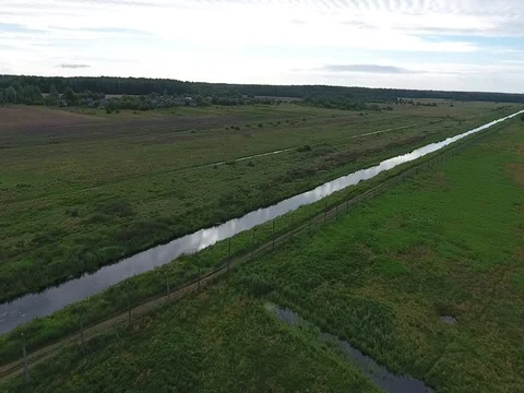 Flying over the field and the river at low altitude Stock Footage 70348298