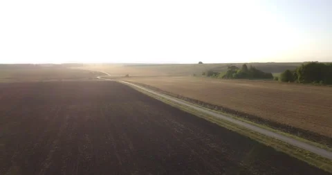 Flying over a field with a road Stock Footage 150432021