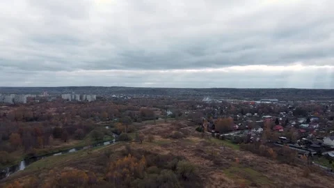 Flying over a field with trees, in the background a river and country houses Vidéo 141543991