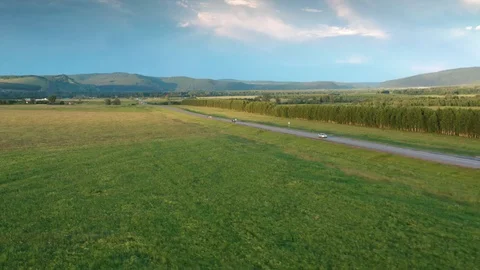 Flying over the fields and follow the road from the side. 스톡 동영상 112097201