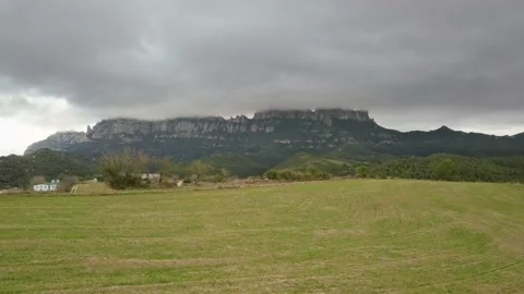 Flying over Fields with Montserrat Mountains at the Background Stock Footage 166472487