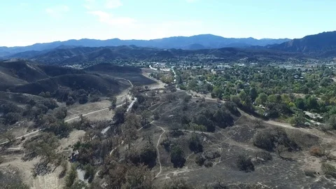 Flying over a fire burn area and horse ranches Stock Footage 100338753