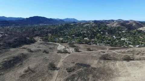 Flying over fire damaged Cheseboro Canyon, approaching horse ranches Stock Footage 100338751