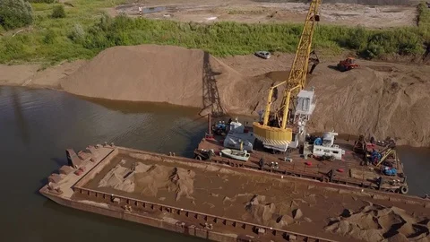 Flying over floating crane and sand barge near river coast, 4k Stock Footage 78537910