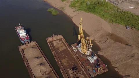 Flying over floating crane and sand barge near river coast, 4k Stock Footage 78537944