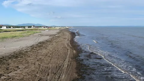 Flying over the foamy waves of the Sea of Okhotsk, running onto a sandy beach Stock Footage 232879351