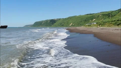 Flying over the foamy waves of the Sea of Okhotsk, running onto a sandy beach Stock Footage 232967290
