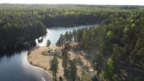 Flying Over A Forest Lake Where The Sun Is Reflected Drone Stock Footage 134075890