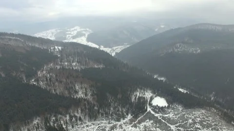 Flying over the forest in the mountains in winter on a cloudy day 02 Stock Footage 58891397