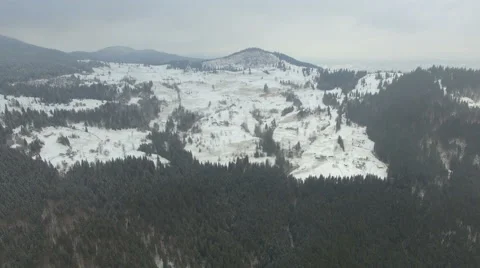 Flying over the forest in the mountains in winter on a cloudy day Stock Footage 58891407