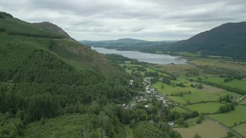 Flying over from forested mountainside to flat patchwork field farmland Stock-Footage 247975652