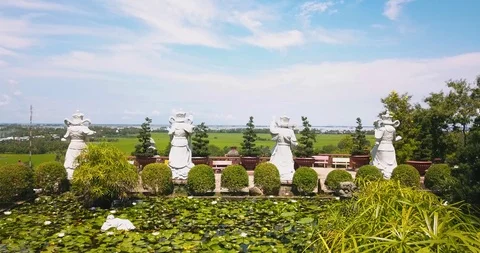 Flying over four statues at Phuoc Dien Temple Stock Footage 116079469
