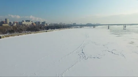Flying over the frozen river in winter. Bridge over river. embankment Stock Footage 60763341