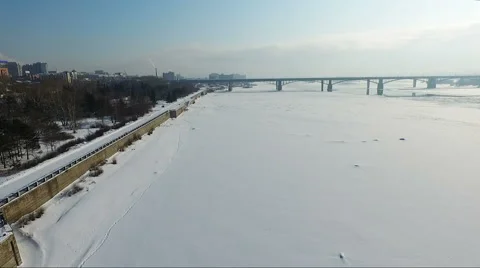 Flying over the frozen river in winter. Bridge over river. embankment Stock Footage 60763389