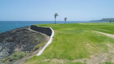 Flying over golf course green field towards blue ocean in sunny day Video stock 89775734