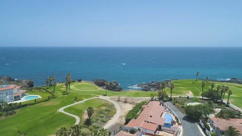 Flying over golf course, view of green field and blue ocean in sunny day Video stock 89630145