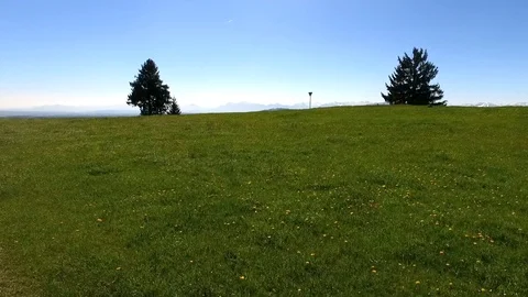 Flying over green fields and hills to the mountains Stock Footage 108811358