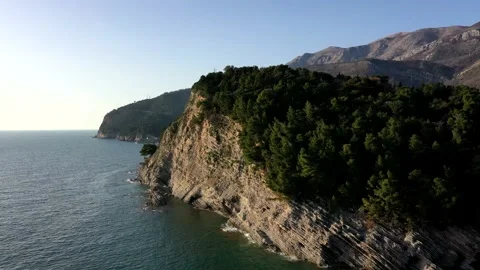 Flying over a green mountain overlooking the city near the sea Stock Footage 153458953