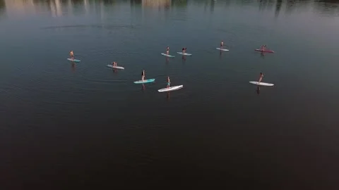 Flying over a group of people exercising on a sup board on a river against the Stock Footage 150781608