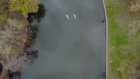Flying over a group of people exercising on a sup board on a river on spring day Stock Footage 153402323