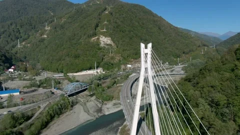 Flying over a high-speed highway in a mountain gorge above a stormy river Video stock 141609596