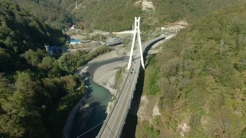 Flying over a high-speed highway in a mountain gorge above a stormy river Video stock 141609657