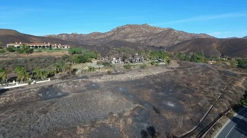 Flying over a hillside home destroyed by wildfire Stock Footage 100339690