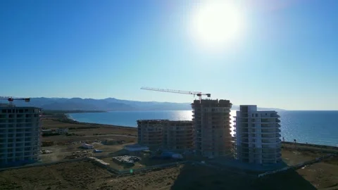 Flying over a hotel construction site on the blue sea. Stock Footage 276294392