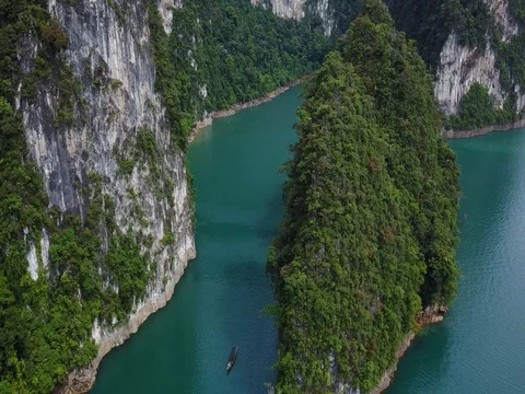 Flying over the Huge rock and Small Thai boat in Cheow Lan Lake 動画素材 78229751