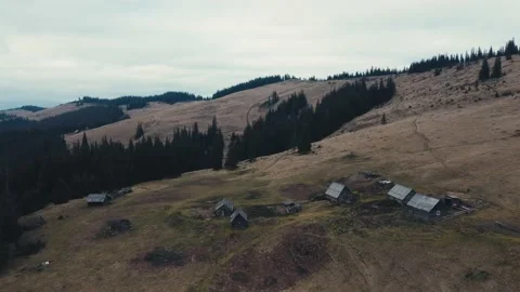 Flying over huts high in mountains. Traditional wooden shepherds house 스톡 동영상 230082280