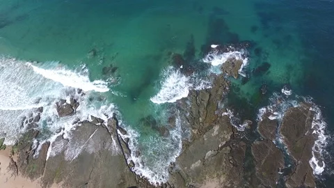 Flying over incoming ocean waves onto rock plateau Video stock 134006429